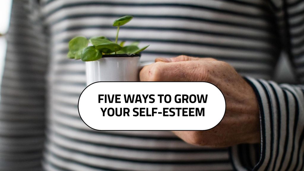 Close up image zoomed in on white person's torso, wearing black and white horizontal striped long-sleeved top, holding small cup with green plant life.