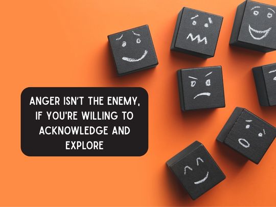 Black cubes with chalk drawn faces expressing a variety of emotions laid against a bold orange background. White upper case text on black text box reads: 'Anger isn't the enemy, if you're willing to acknowledge and explore'.